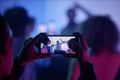 Closeup of man filming DJ at disco party via smartphone - PhotoDune Item for Sale