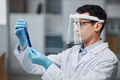 Scientist wearing face shield in laboratory doing experiments with test tube - PhotoDune Item for Sale