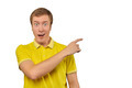 Surprised guy with funny face in bright yellow T-shirt pointing finger to right, white background - PhotoDune Item for Sale