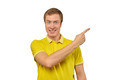 Smiling guy with funny face in yellow T-shirt pointing finger to right, white background - PhotoDune Item for Sale