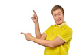Surprised guy with funny face in yellow Polo T-shirt pointing finger to left, white background - PhotoDune Item for Sale