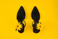 Suede black court shoes with yellow Topinambur flower bud on strap, yellow background, trendy shoes - PhotoDune Item for Sale