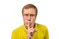 Funny young man in yellow T-shirt asking to be quiet, silence gesture, white background - PhotoDune Item for Sale