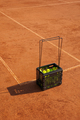 tennis green balls in black basket court made of red clay soil with markings for game or competition - PhotoDune Item for Sale