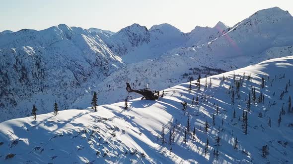 Actionsportlers were dropped by a helicopter at the top of the mountains. Drone shooting.