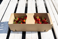 Fresh strawberries in a cardboard basket, lying on a white pallet. - PhotoDune Item for Sale