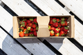 Fresh strawberries in a cardboard basket, lying on a white pallet. - PhotoDune Item for Sale