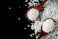 White uncooked rice in wooden spoons on black background. Raw grains of long rice. - PhotoDune Item for Sale