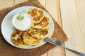Vegan zucchini pancakes in plate and cream sauce on wooden background. Healthy vegan diet food. - PhotoDune Item for Sale