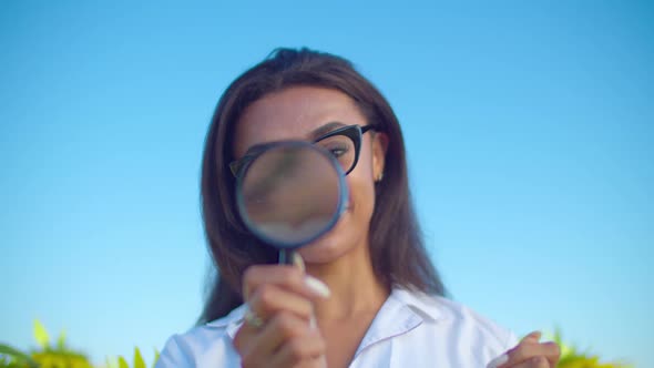 Crop Scientist Looking Through Magnifier in Nature