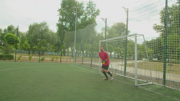 Football Goalie Punching Soccer Ball Away From Penalty Area Outdoors