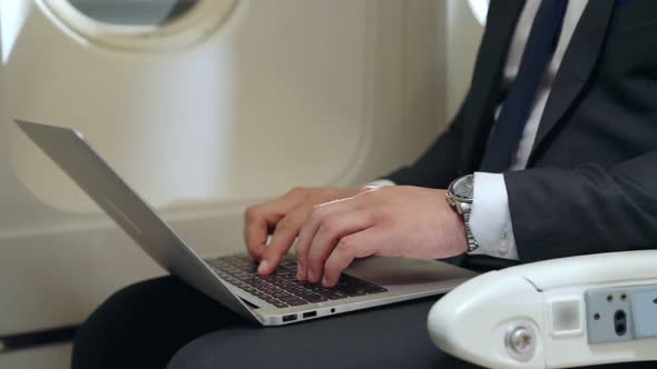 Young Businessman Using Laptop Computer in Airplane