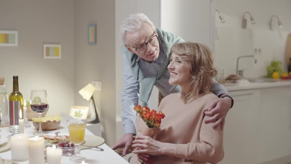 Loving Elderly Couple Posing for Camera at Romantic Dinner