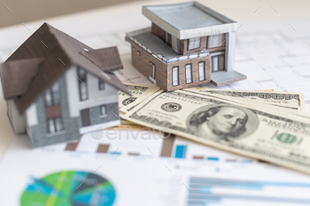 paper house model on background of US dollars banknotes. Housing market, purchase or rental of real