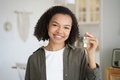 Smiling mixed race teen girl tenant or homeowner holds keys to new home. Rental housing, mortgage - PhotoDune Item for Sale