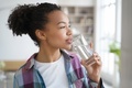 Mixed race young girl drink pure water from glass at home. Healthy lifestyle, morning routine - PhotoDune Item for Sale
