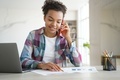 Mixed race teen girl school student call by phone, discussing homework with friend, sitting at desk - PhotoDune Item for Sale