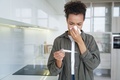 Sick mixed race girl blowing nose checks temperature using electronic thermometer at home. Flu fever - PhotoDune Item for Sale