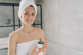 Woman holding mockup cosmetics jar with cream, advertising skincare beauty product in bathroom - PhotoDune Item for Sale