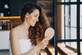 Young girl combing long healthy hair by wooden hairbrush after shower. Haircare cosmetic advertising - PhotoDune Item for Sale
