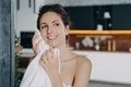 Woman wiping facial skin with towel after washing in the morning at home. Daily skincare routine - PhotoDune Item for Sale