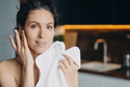 Beautiful woman enjoying healthy smooth skin after washing face, holding towel. Skincare at home - PhotoDune Item for Sale