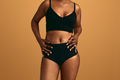Crop black obese woman in underwear standing against beige background - PhotoDune Item for Sale