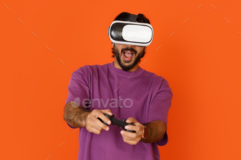 Dark-skinned man playing video games, using VR glasses, joystick