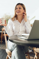 Smiling businesswoman drinking coffee at table with netbook in cafe - PhotoDune Item for Sale