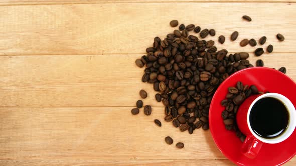 Close-up of coffee cup with saucer and coffee beans