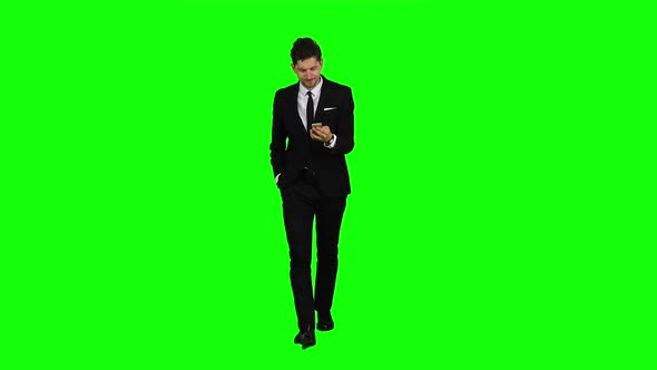 Businessman Is a Telephone Rings To Him and He Talks. Green Screen