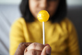 child holding yellow color lollipop candy  - PhotoDune Item for Sale