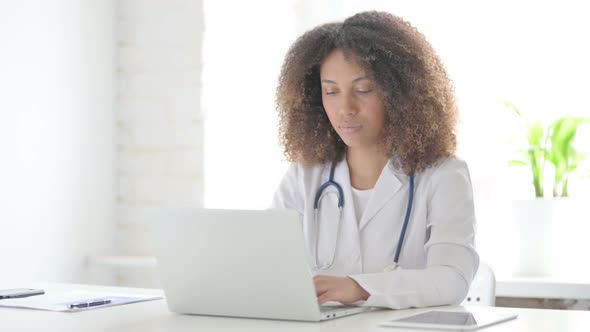 Afrcian Doctor Shaking Head as No Sign while using Laptop in Clinic