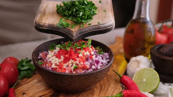Cooking Salsa Dip Sauce Woman Pours Chopped Cilantro or Parsley Greens Into Wooden Bowl with