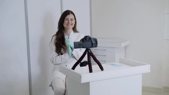 Cheerful Female Doctor in Uniform Recording Video for Vlog in Front of Camera