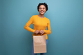 young pretty latin woman with afro hair holding craft eco bag on studio background - PhotoDune Item for Sale