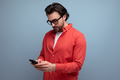 smart young brunette man in glasses and red shirt chatting on the phone - PhotoDune Item for Sale