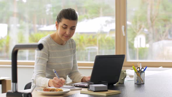 Young Woman with Laptop Working at Home Office