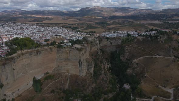 Drone Footage of Ronda City on Top of a Cliff with Mountains Near It
