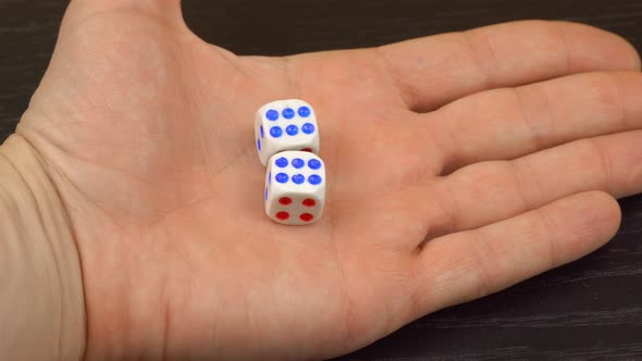 a man's hand holds dice in the palm of his hand