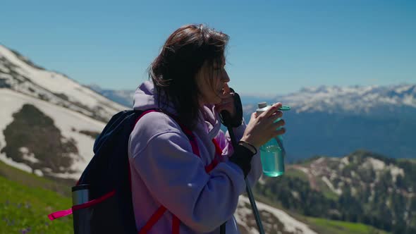 Girl Backpacker Needs to Take Rest and Quench Her Thirst