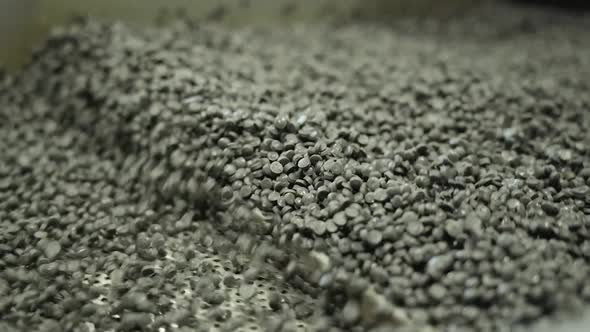 The Plastic Granules Move Along a Vibrating Metal Conveyor