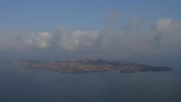 Time Lapse shot of low altitude clouds traveling over the volcanic island of Nea Kameni, as seen fro