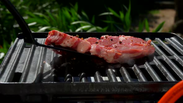 Cook Lays a Raw Pork Steak with a Kitchen Spatula