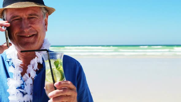 Senior man talking on mobile phone on the phone at the beach