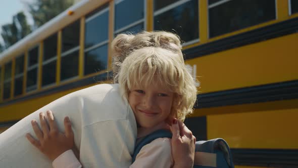 Mother Meeting Son Hugging at School Bus