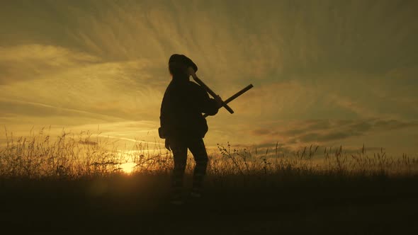 Cute Child Playing with Toy Wooden Airplane in the Field at Sunset Time. Silhouette of Kid Playing