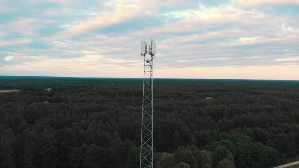 Aerial View of the 5G Antenna Rising Above the Road and Fields with Trees. Countryside. Ascending