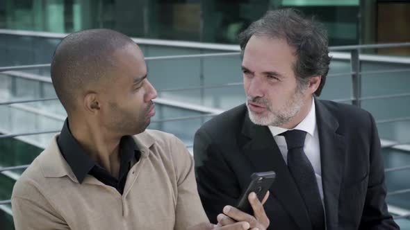 Male Office Professionals Sitting Outdoors During Work Break