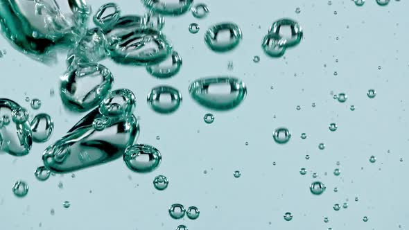 Macro Shot of Air Bubbles in Water Rising Up on Light Blue Background